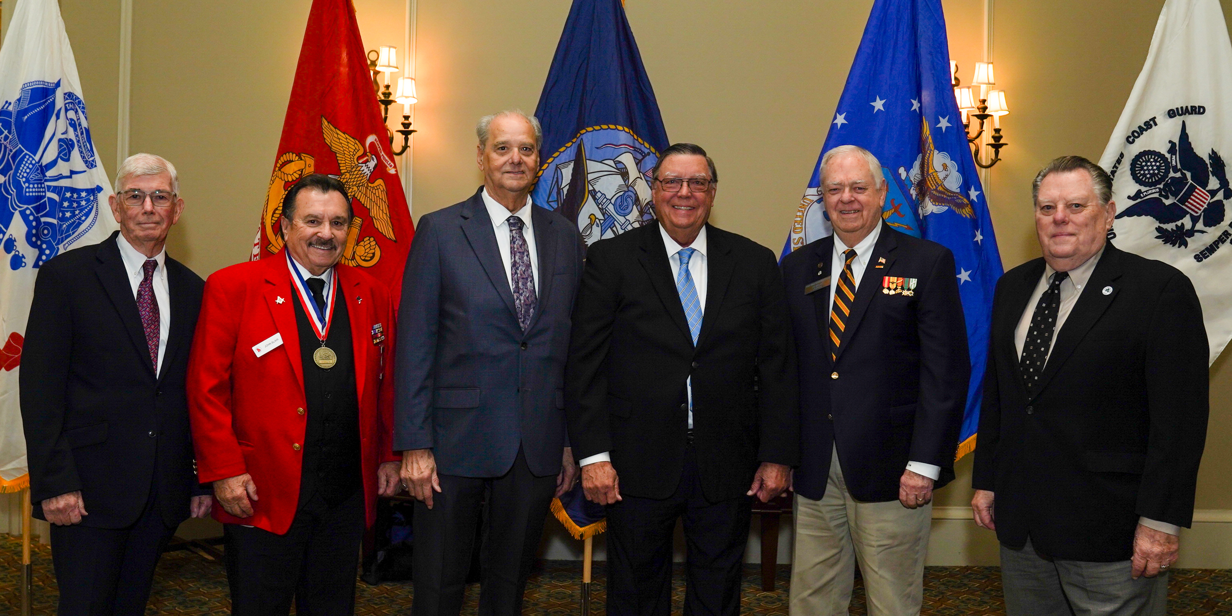 Inductees in front of military flags